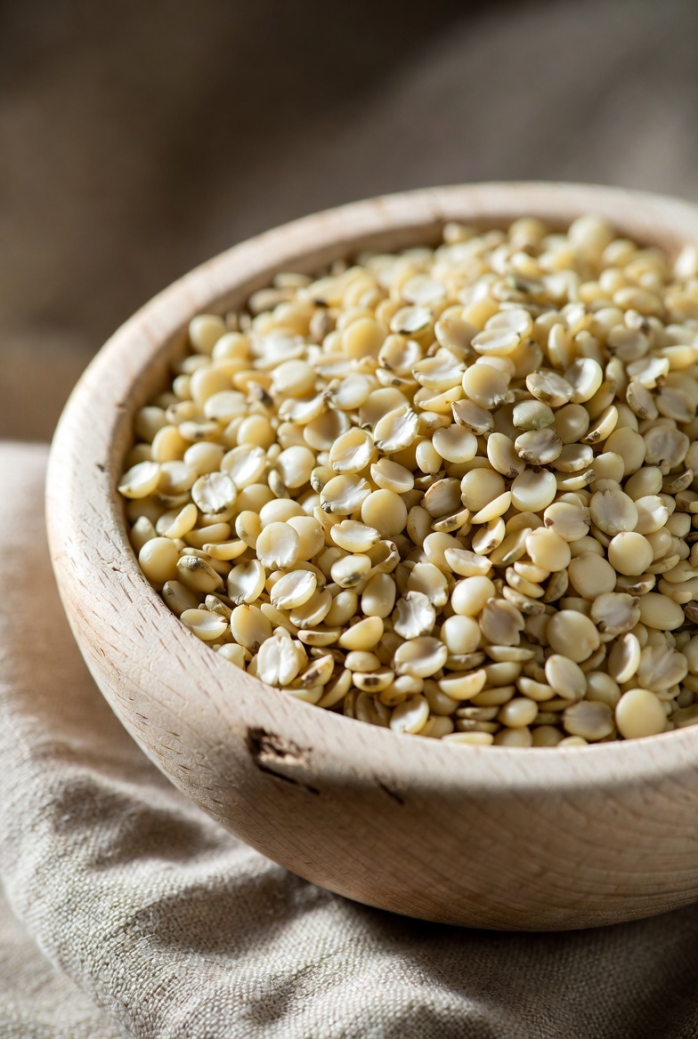 Raw hemp seeds (hemp hearts) from the Cannabis sativa plant in a wooden bowl in natural light.